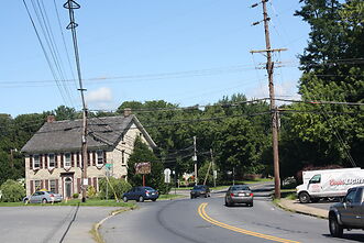photo shows stems place from the road, as cars are passing by.